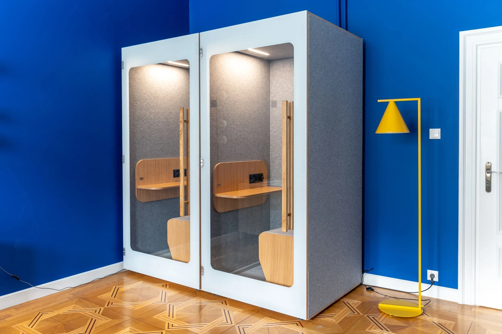 Cabine acoustique NINA installée dans un espace patrimonial mur bleu