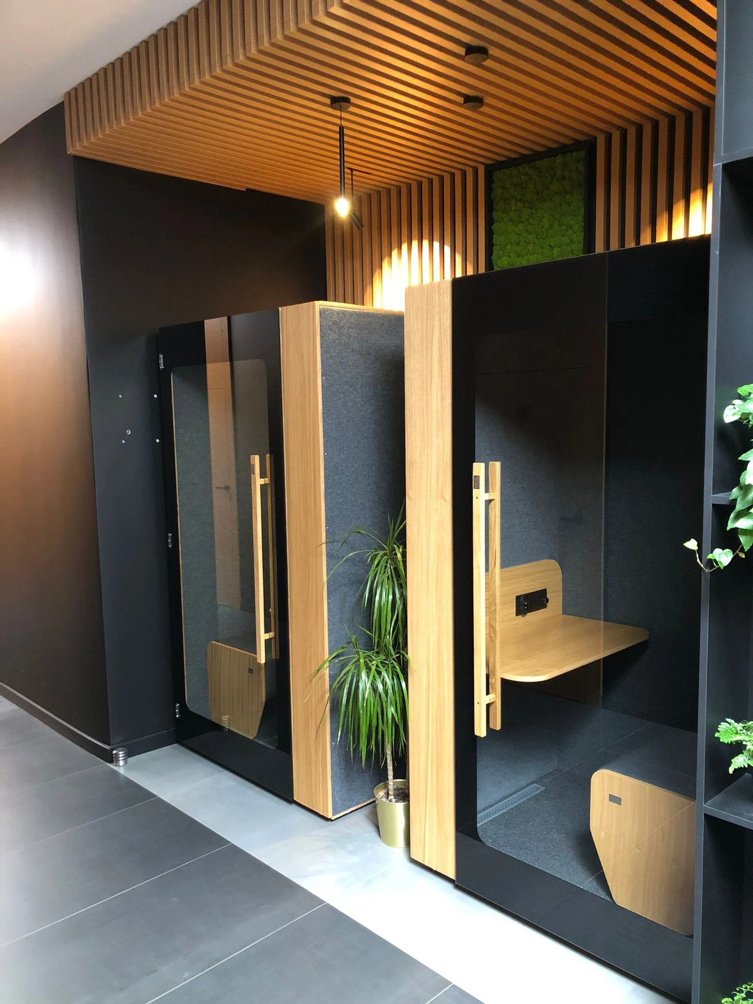 Cabine acoustique NINA+ finition noire en couloir design avec mur végétal