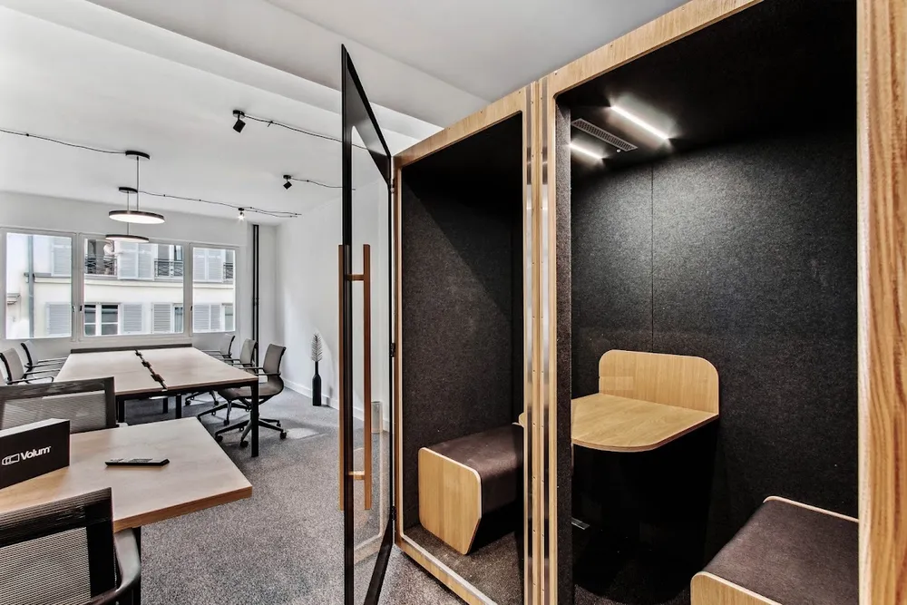 Cabine acoustique avec bureau intégré dans un open-space lumineux